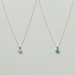 Blue and white opal pendant with sterling silver chain necklaces displayed side by side on a white background