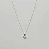 Opal pendant necklace laid flat, featuring a luminous round white opal on a silver chain