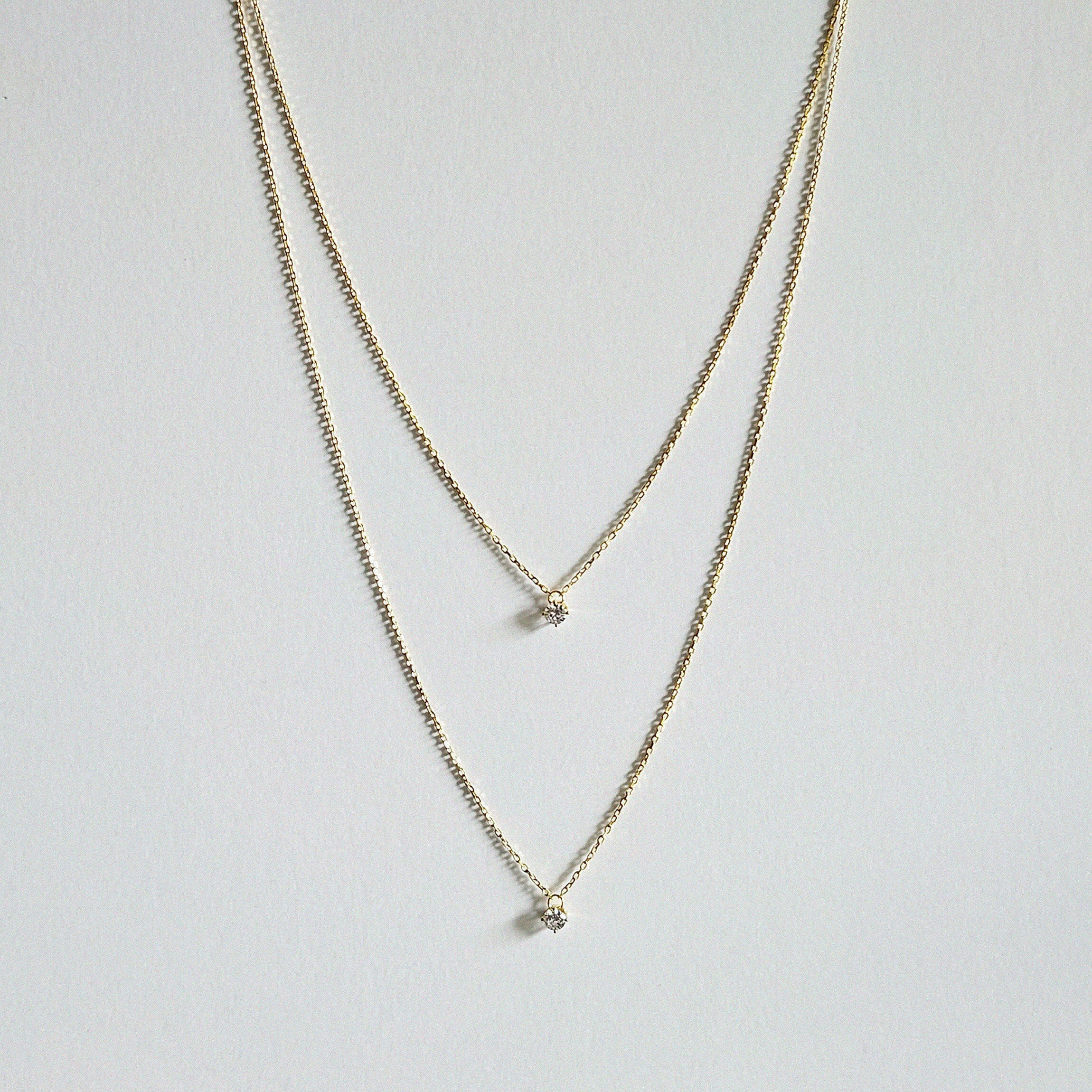 Petite Crystal Double Chain Necklace in gold displayed in a soft curve with double-layered chains
