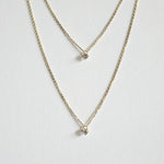 Close-up of crystal pendant between two chains arranged neatly