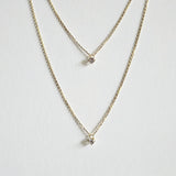 Close-up of crystal pendant between two chains arranged neatly