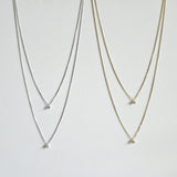 Gold and silver double chain necklaces laid flat showing cubic zirconia placement