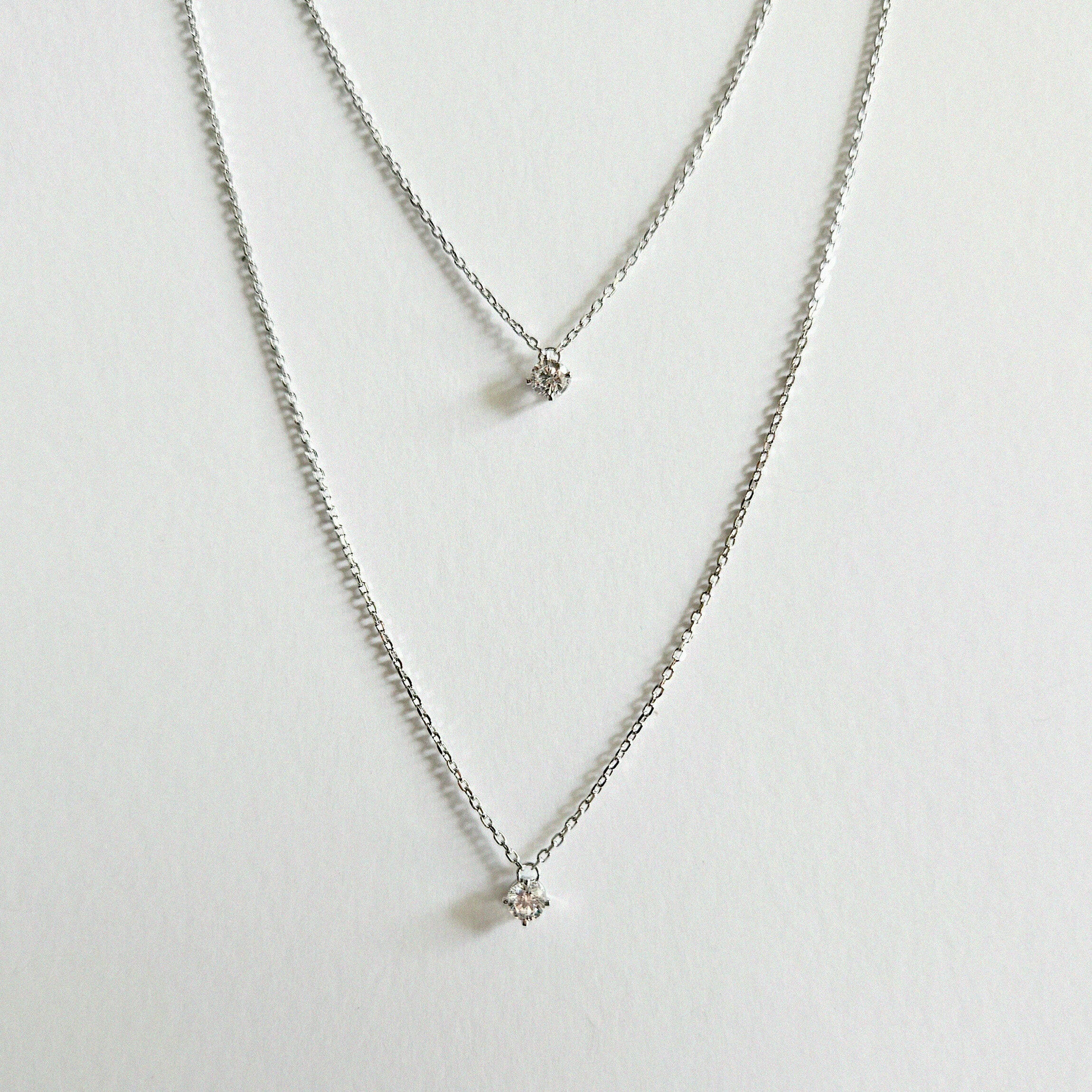 Petite Crystal Double Chain Necklace in silver displayed in a soft curve with double-layered chains
