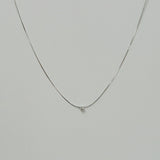 Petite crystal snake chain necklace in silver laid flat in a delicate curve with cubic zirconia accent.