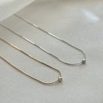 Sterling silver and gold versions of delicate snake chain necklace shown side by side