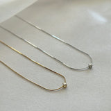 Sterling silver and gold versions of delicate snake chain necklace shown side by side