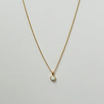Delicate circular white opal necklaces arranged in a minimal flat lay