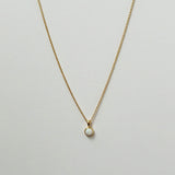 Delicate circular white opal necklaces arranged in a minimal flat lay