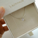 Silver necklace with a pendant in an open jewelry box labeled 'Laondrim'.