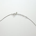 Silver necklace on a light gray background
