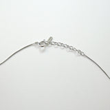 Silver necklace on a light gray background