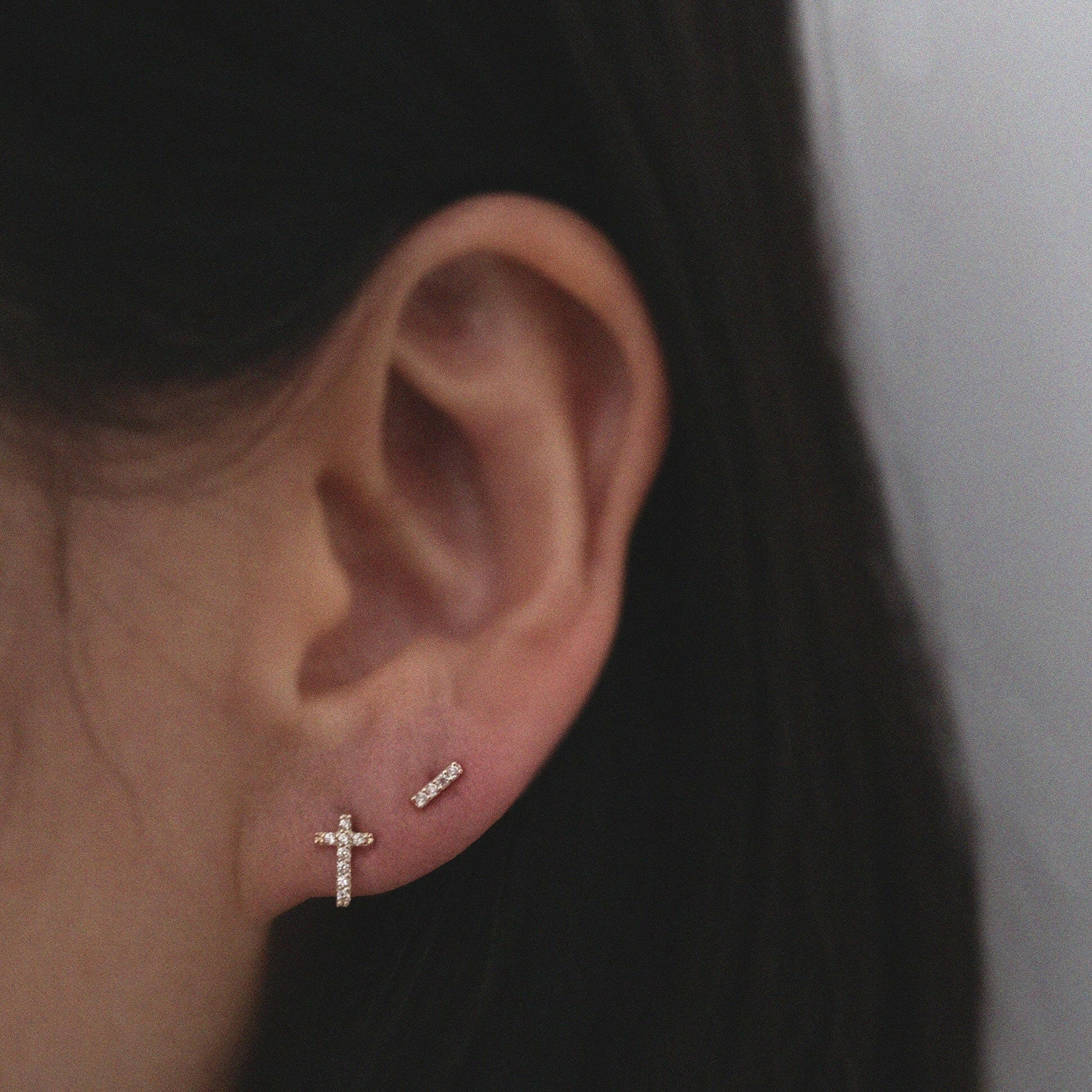 Model styling CZ line studs with minimalist cross studs for a modern look