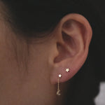 Model wearing Petite Star Studs in second piercing with celestial drop chain studs