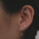 Model wearing Petite Star Studs in second piercing with celestial drop chain studs