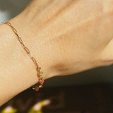 Dainty link and gemstone bracelet styled solo on wrist with bright natural light
