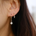 Olivia earrings paired with small dangly gemstone studs in chic styling