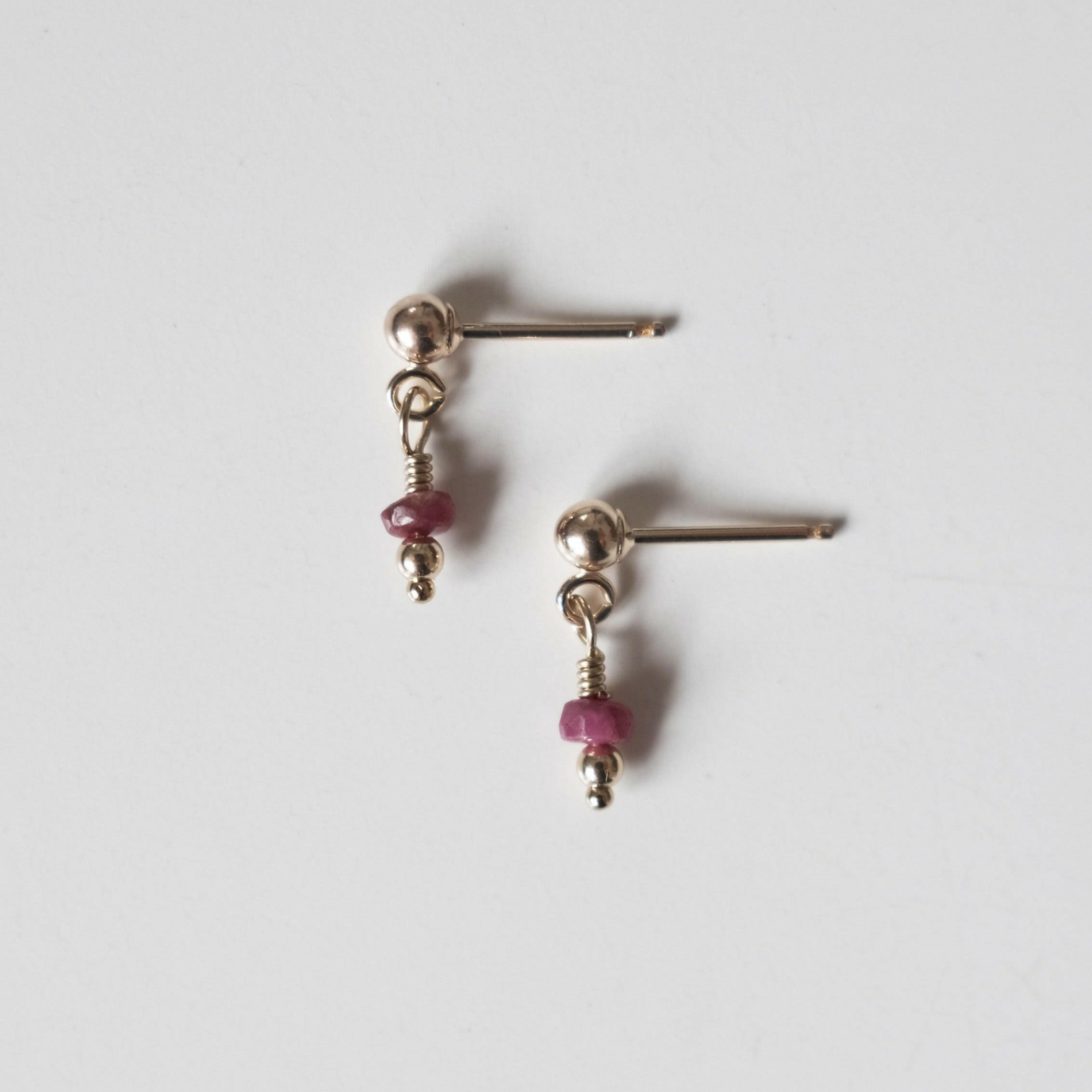 Petite gold drop earrings with small round ruby gemstones and gold posts